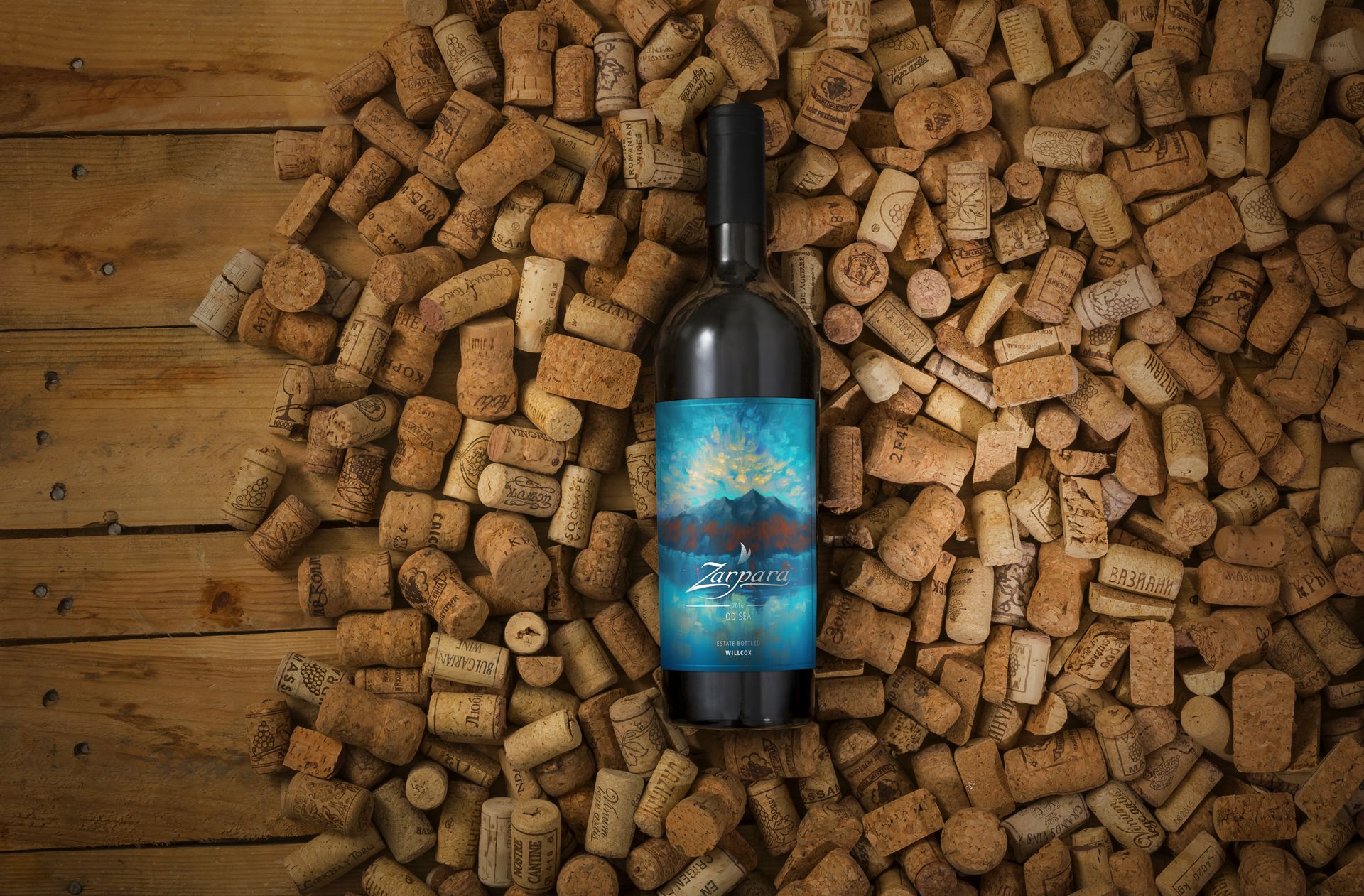 A mockup of Zarpara's red wine bottle and its label design; the bottle sits on a bed of corks