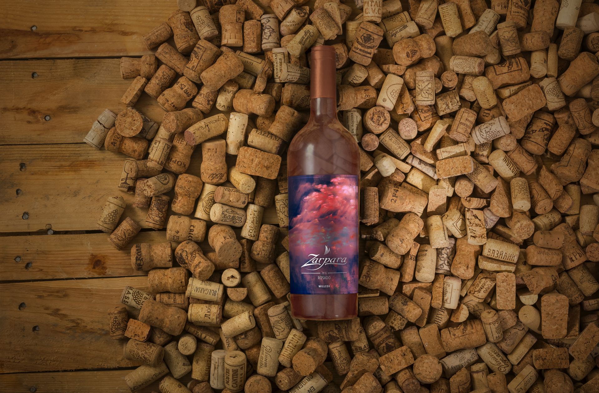 A mockup of Zarpara's rosé wine bottle and its label design; the bottle sits on a bed of corks