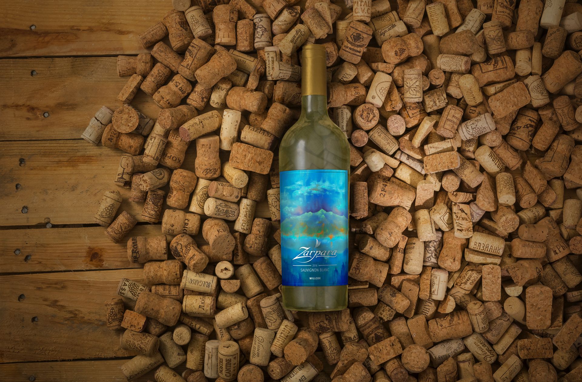 A mockup of Zarpara's white wine bottle and its label design; the bottle sits on a bed of corks